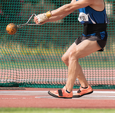 a person holding a hammer in the middle of doing a hammer throw