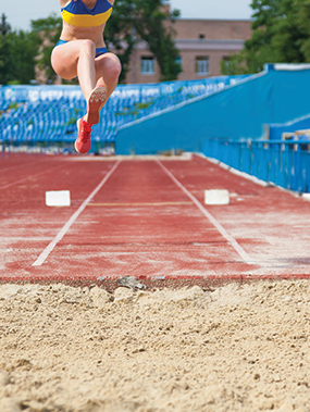 a person in midair in the middle of performing a triple jump